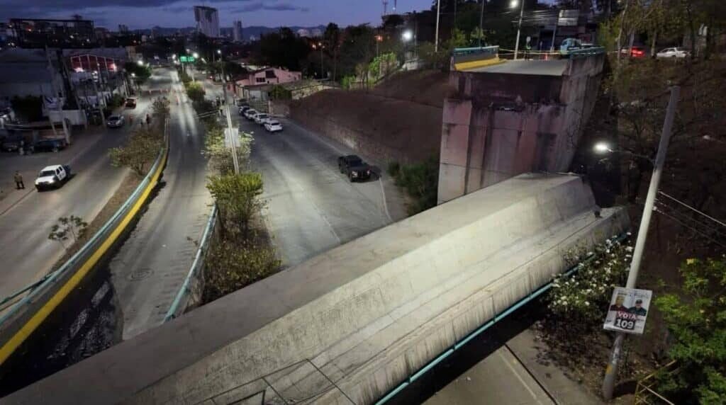 Tramo del puente a desnivel colapsado en Tegucigalpa, con el tablero desplazado y caído junto al estribo