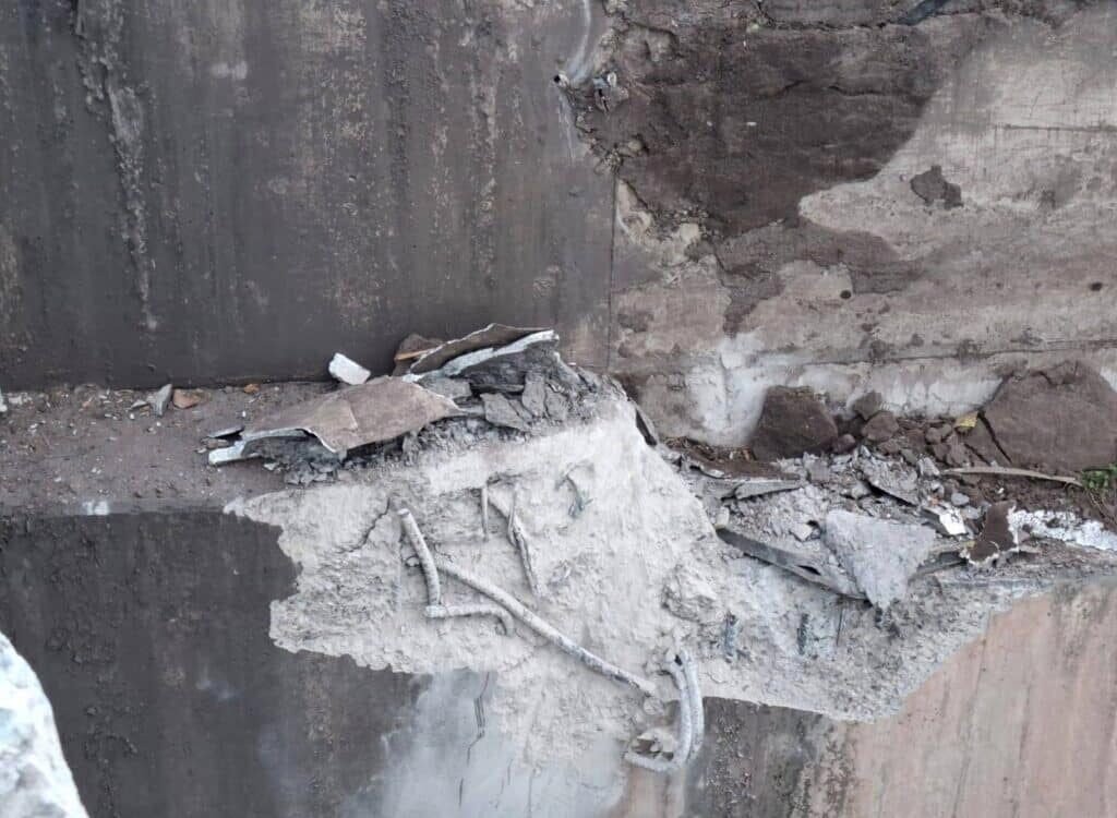 Daño estructural severo en el apoyo del puente, con concreto desprendido y acero expuesto